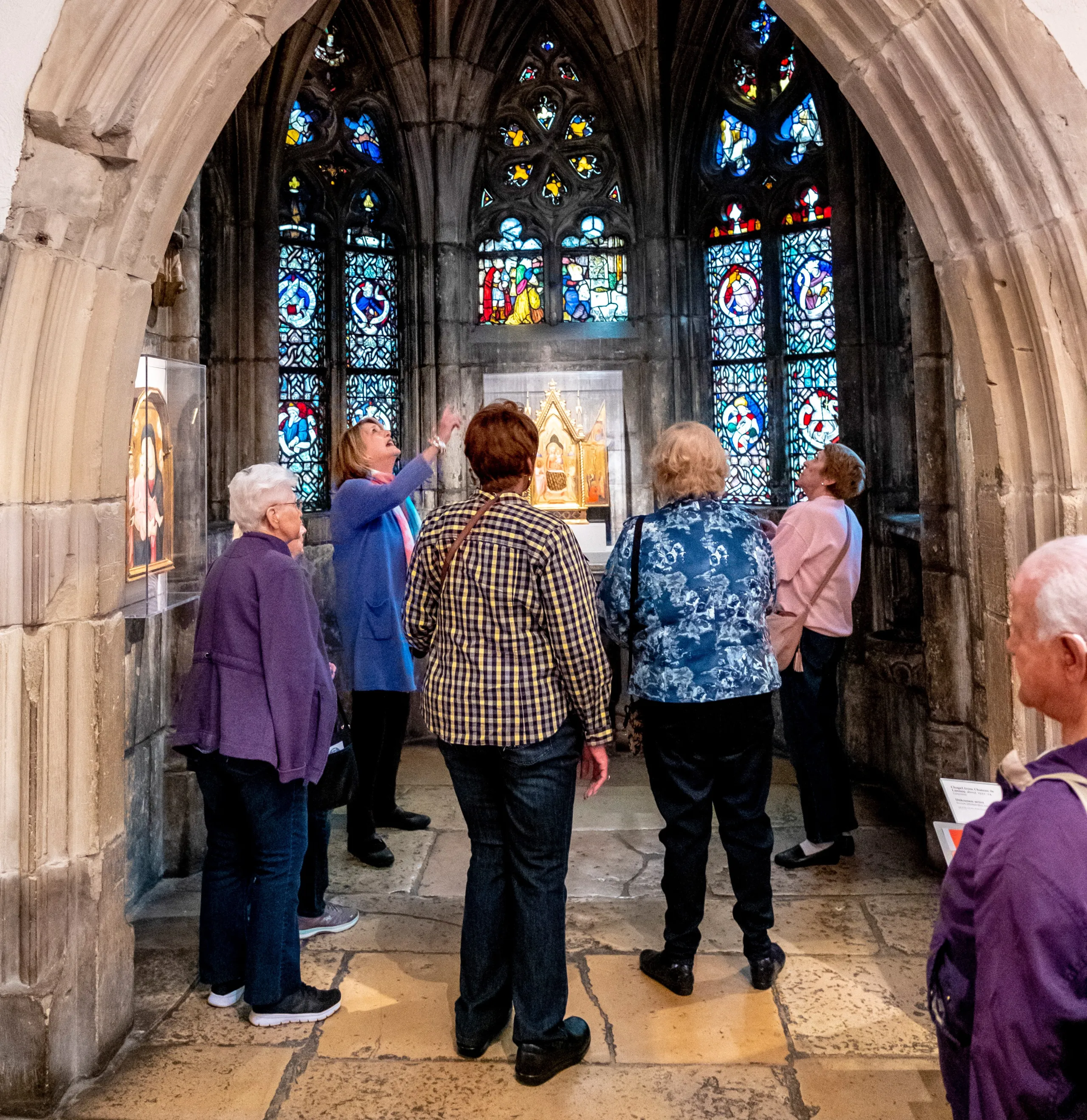Group of seniors looks at stained glass. 