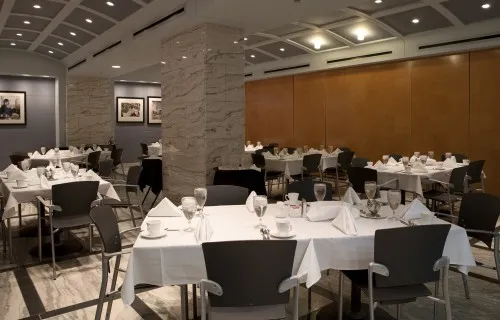 An array of tables set for a meal with white linen in FJC Dining Room B