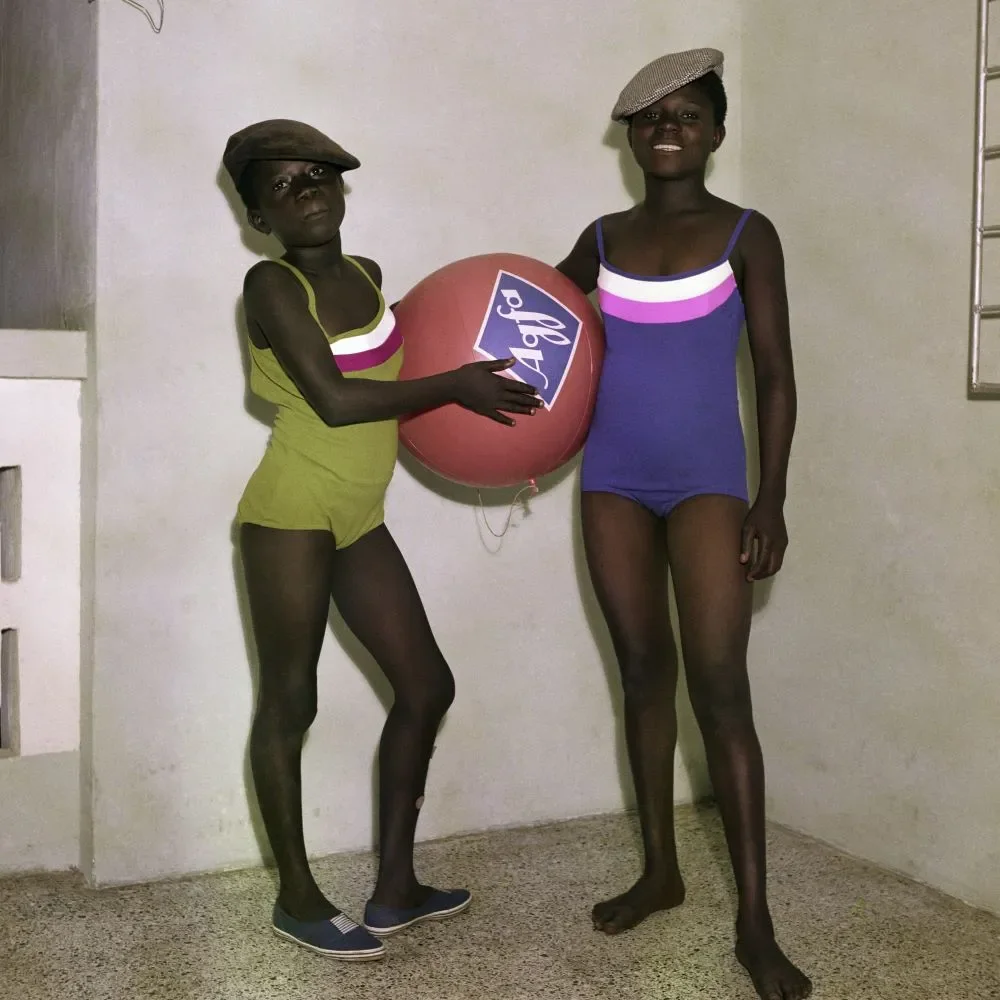 James Barnor (Ghana, b. 1929). Untitled #7 (Barnor’s daughters Mavis and Mary Barnor with an Agfa-Gevaert promotional ball), Accra, 1970 (printed 2010–20). Chromogenic print. Autograph, London.