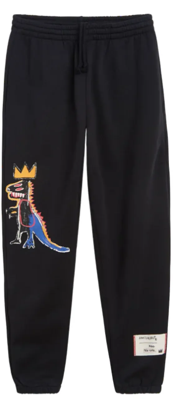 These medium weight fleece sweatpants feature the printed image of Basquiat’s “Pez Dispenser” dinosaur on the knee of the front right leg, and a woven tag at the bottom of the right leg, featuring text pulled from Basquiat’s notebooks in his handwriting. The sweatpants are ribbed at the cuff and hem.