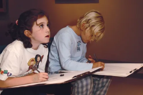 Two girls jotting down notes