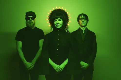 Infinite River pose as a trio dressed in black with a green hue overlayed.