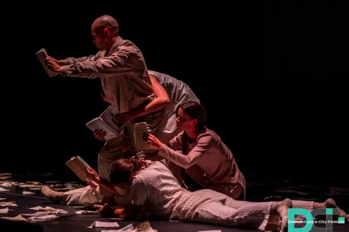 Dancers on stage mimicking reading books.