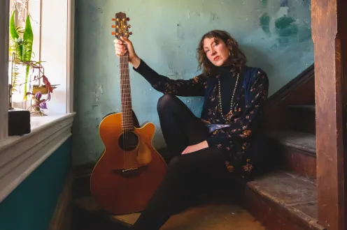 Audra Kubat posing with a guitar