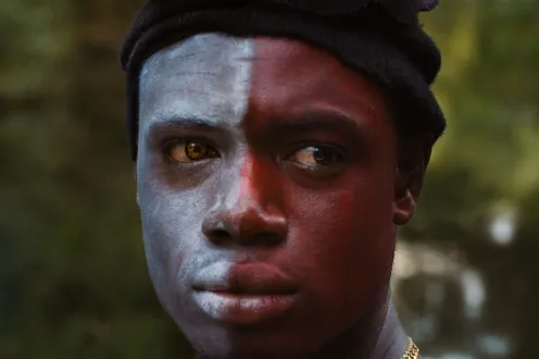 A man with half of his face painted red and half painted white