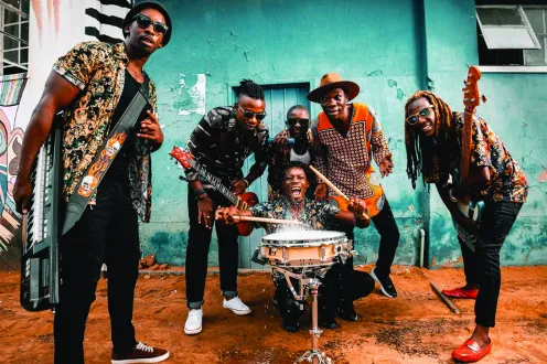 A group of musicians pose together with their instruments