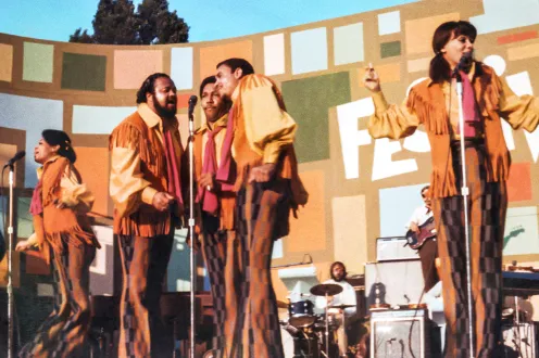 Musicians performing on stage in 70s garb
