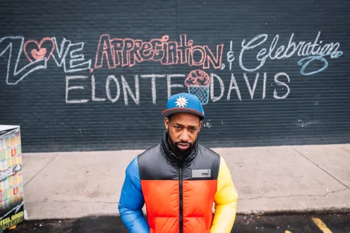 Elonte Davis stands in front of wall that says "love, appreciation & celebration, Elonte Davis"