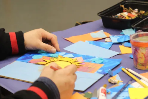 Hands work on a paper craft project in the Detroit Institute of Arts' Artmaking Studio