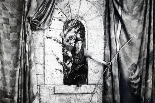 Man with an arrow standing on a window sill. 