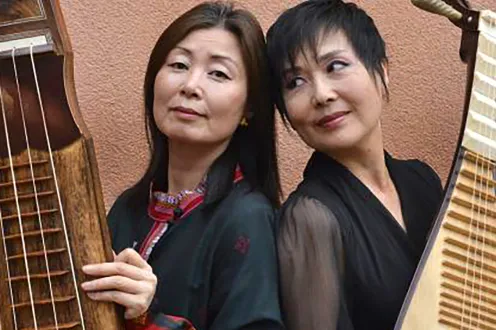 Two women holding large string instruments