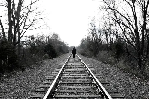 A person walking in the distance on train tracks
