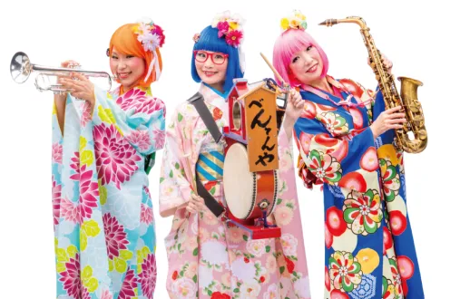Three women holding instruments and wearing colorful kimonos