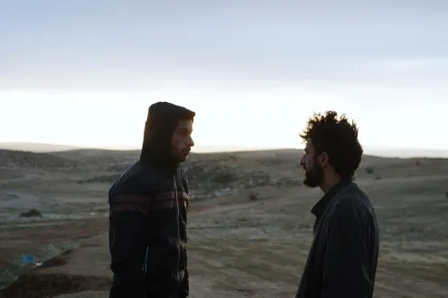 Two people face each other in a desert