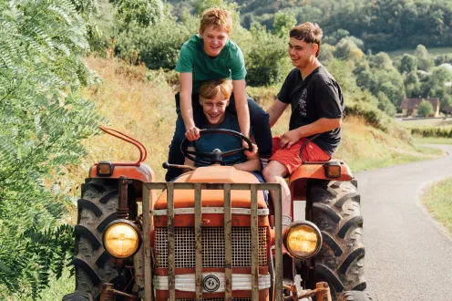 Three kids on an older red tractor