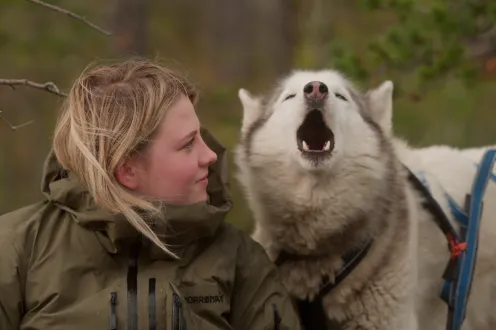 A blond woman with an Alaskan husky