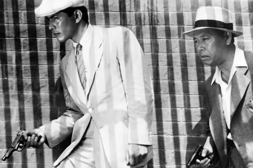 Two men with guns in suits and hats