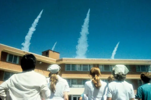 People stop to look at smoke in the sky