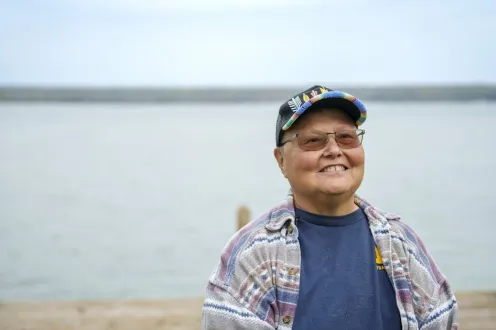 A person standing in front of a dock at a lake
