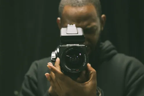 Elonte Davis facing the camera, holding a camera