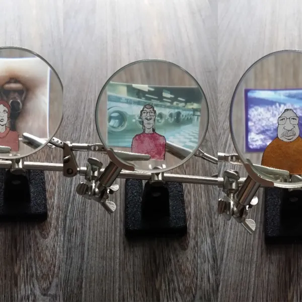 Three small magnifying glasses showing detailed views of three very small portraits