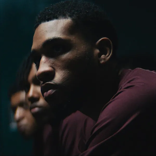 Men in maroon shirts sitting in a row