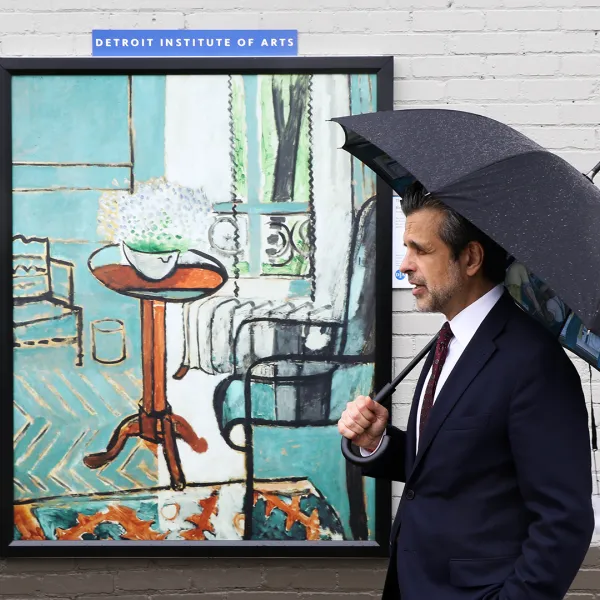Salvador Salort Pons poses with an umbrella in front of an Inside Out artwork.