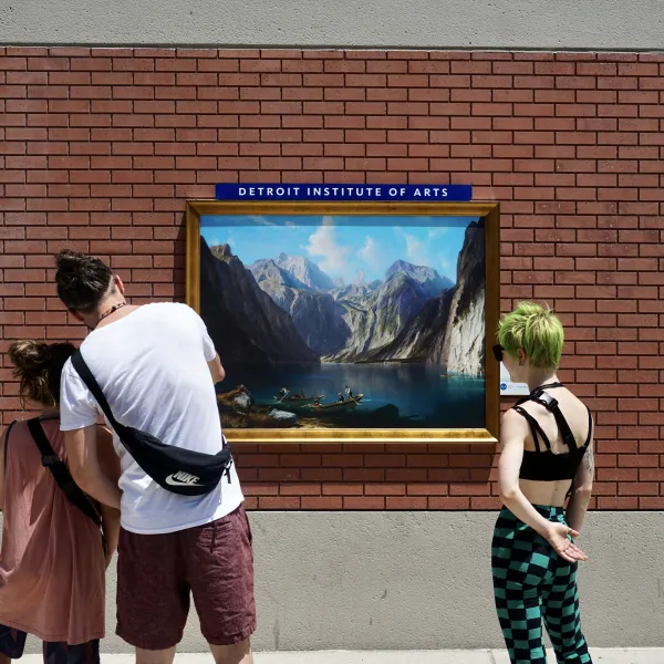 Three friends looking at an artwork on the side of a building during an Inside|Out Installation