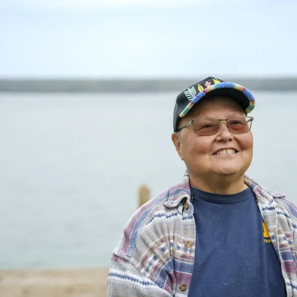 A person standing in front of a dock at a lake